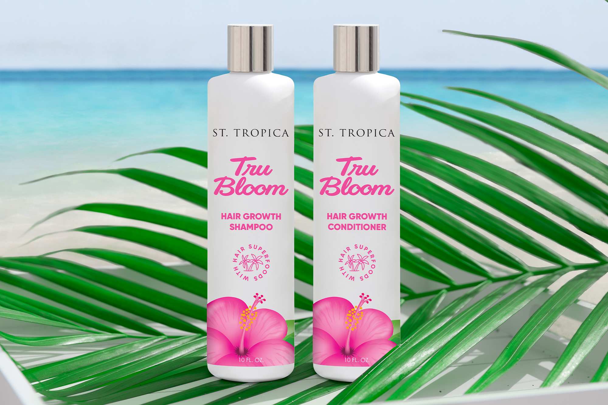 The Tru Bloom Hair Growth Shampoo and Conditioner sitting on a palm leaf on a tropical beach