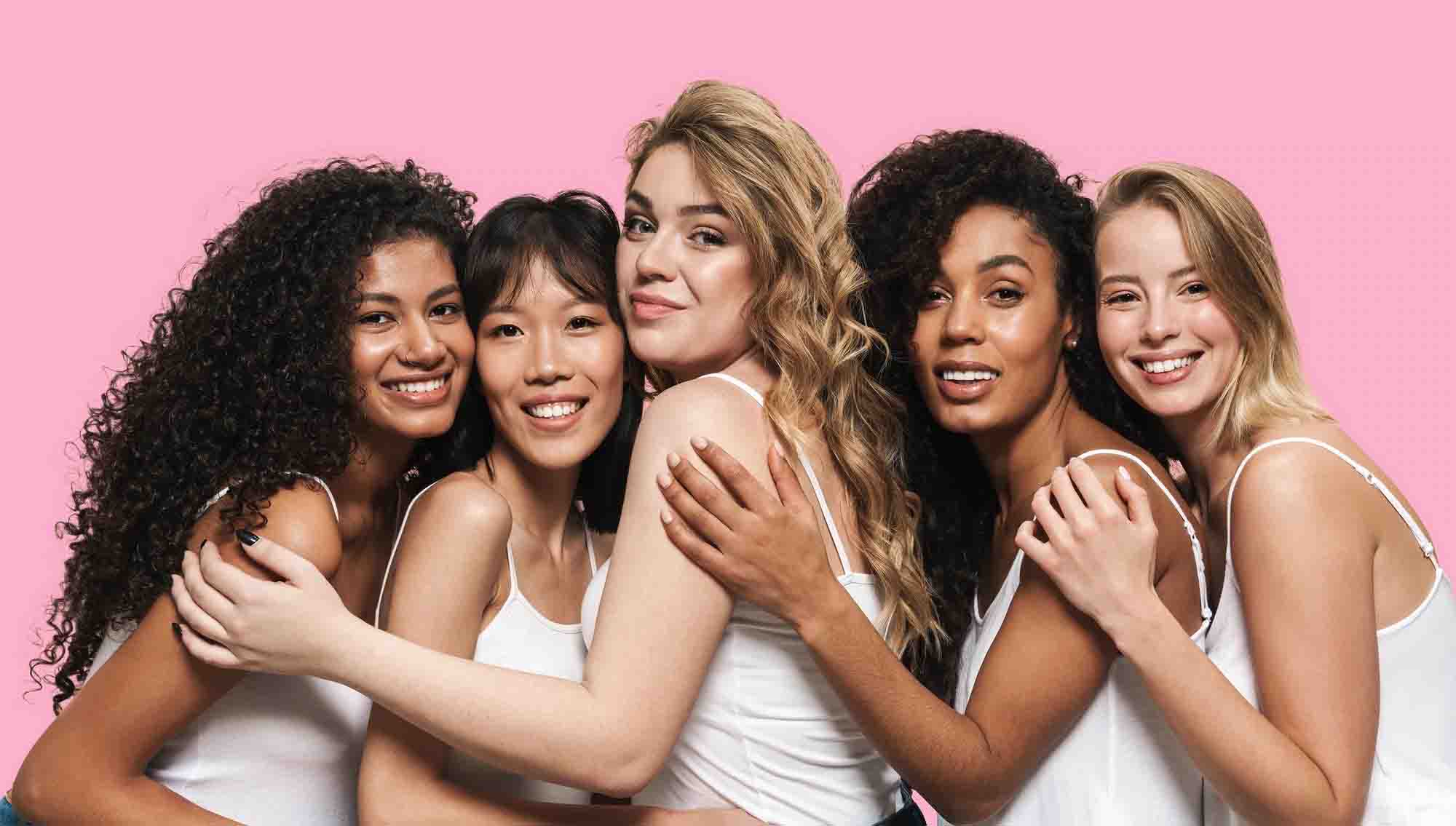 Five women embracing eachother and smiling 